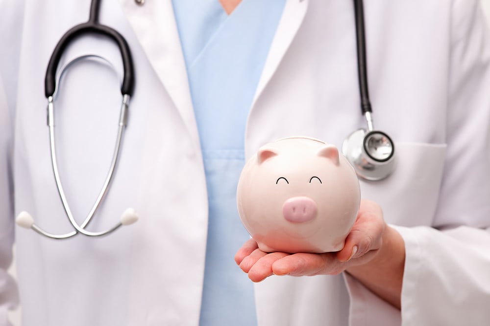 medical person holding piggy bank